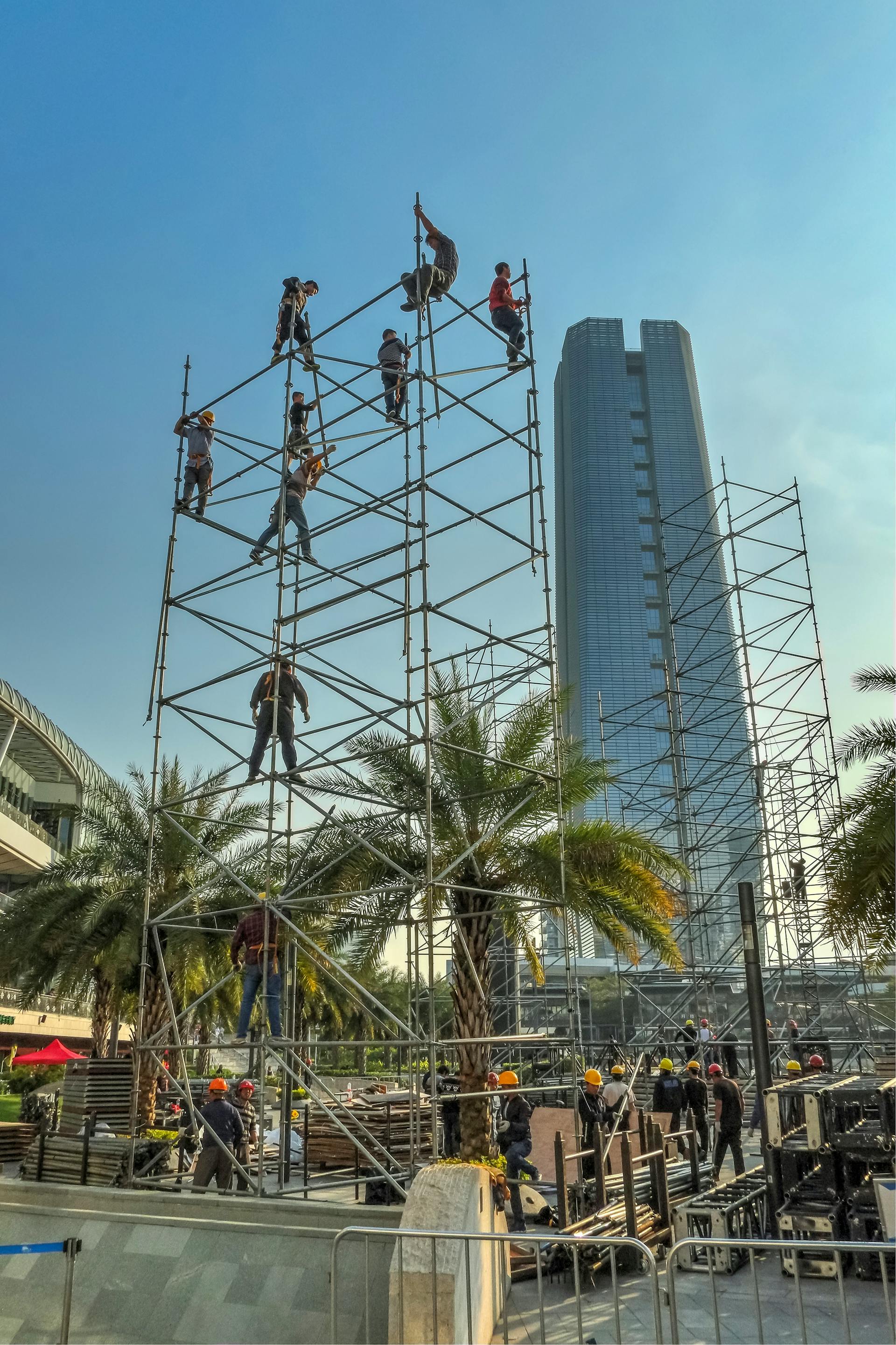 Professional scaffolding crew constructing steel framework at height with skyscraper in background — Scaffex Kosovo